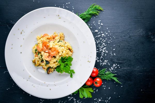 Risotto with shrimp. On a wooden background. Top view. Free space for your text.
