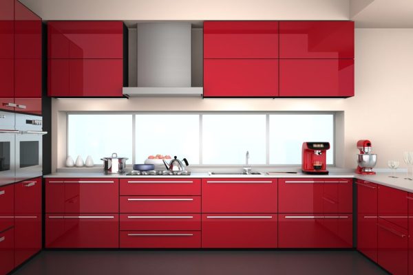 Front view of modern kitchen interior in red color theme.