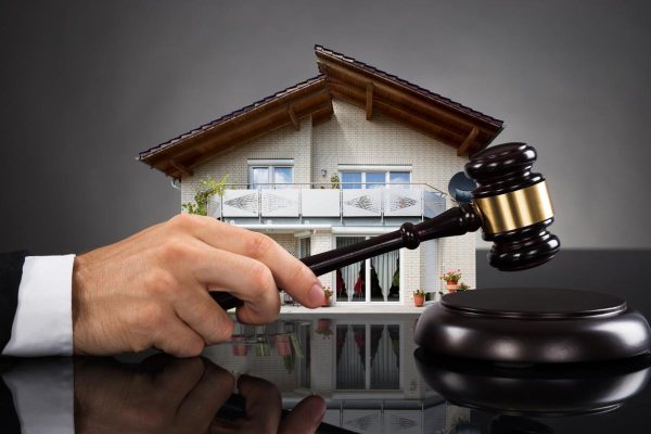 Judge With House Model Hitting Gavel