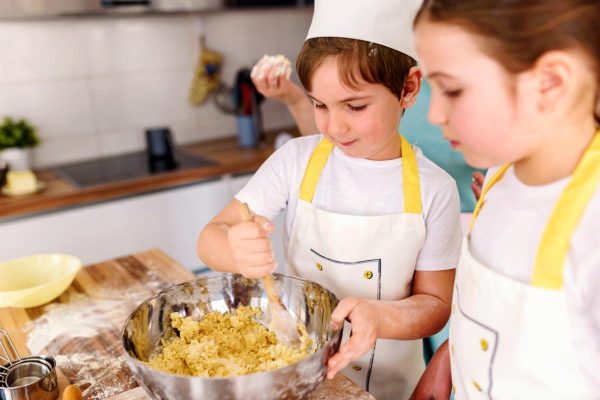 Children helping mother in the kitchen baking together