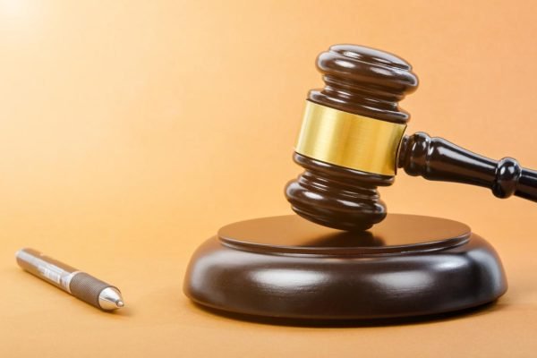 Wooden judge gavel with pen.