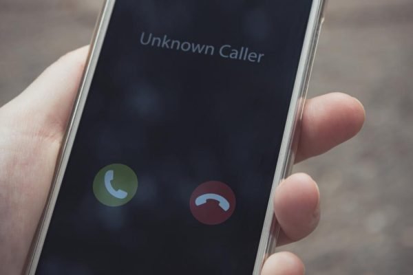 Unknown caller. A woman holds a phone in his hand outdoors in a park and thinks to end the call. Incoming from an unknown number. Incognito or anonymous