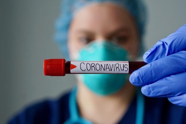 Nurse wearing respirator mask holding a positive blood test result for the new rapidly spreading Coronavirus, originating in Wuhan, China