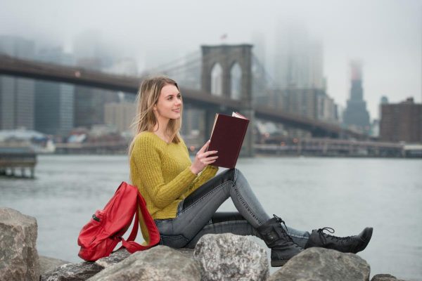 Young beautiful student girl reading a book