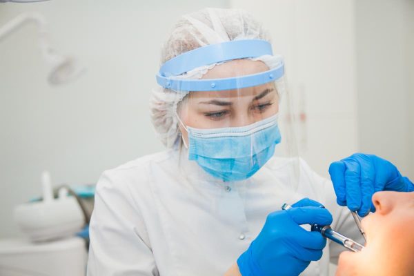 Dentist caries treatment at dental clinic office.