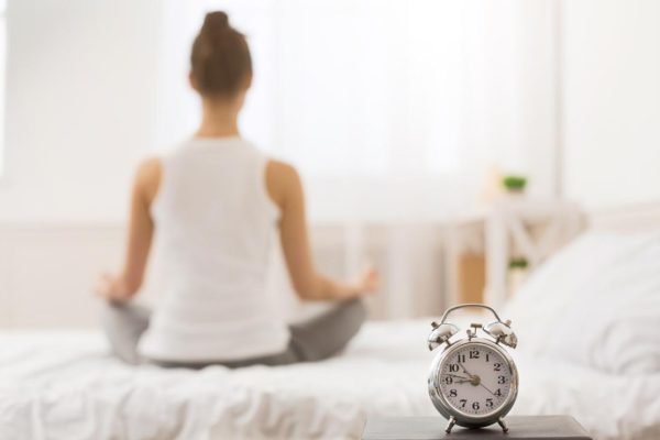 Early awakening. Woman practicing yoga in the morning