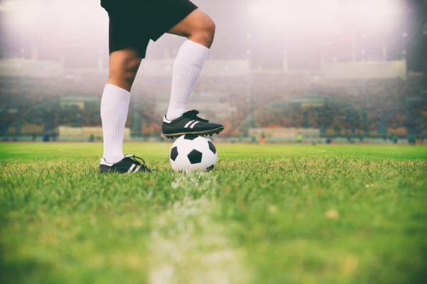 soccer or football player standing with ball on the field for Kick the soccer ball soft focus and selective focus on grass