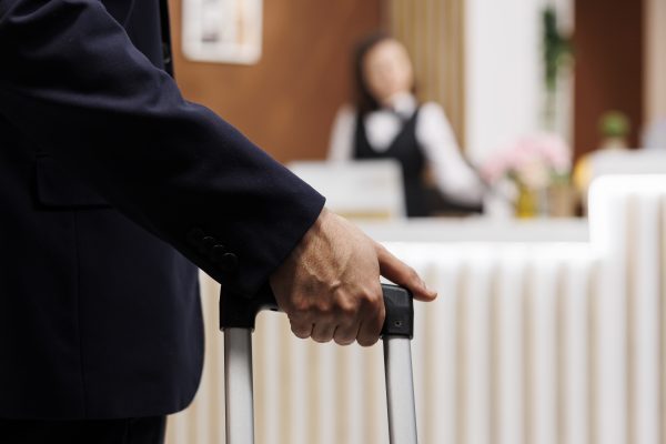 Hotel guest enter reception with luggage